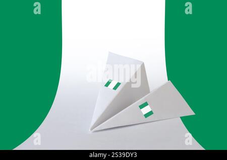 Drapeau du Nigeria représenté sur un avion en origami en papier. Concept d'arts orientaux faits à la main. Drapeau du Nigeria représenté sur un avion en origami en papier. Arts faits main Banque D'Images
