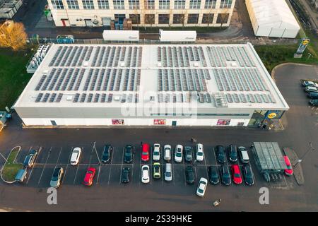 Siauliai, Lituanie - 17 novembre 2024 : voitures aériennes top down dans le parking et les clients vont faire leurs courses au supermarché allemand Lidl avec solaire Banque D'Images