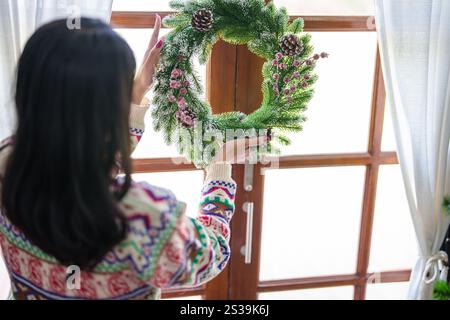 Femme faisant couronne de gui décoration de couronne de Noël avec des mains de fleuriste de verdure d'hiver faites à la main faisant couronne de Noël belle gui Banque D'Images