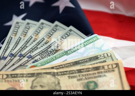 Résident permanent carte verte des États-Unis d'Amérique et billets d'un dollar sur drapeau américain plié gros plan. Résident permanent États-Unis d'Amérique Green Banque D'Images