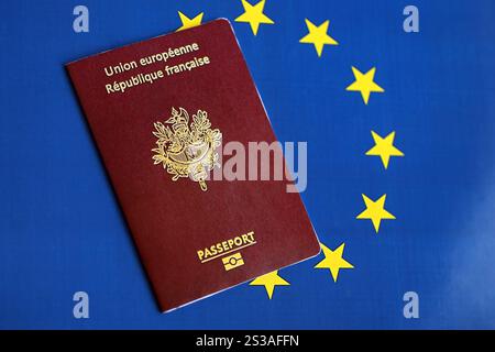 Passeport français de l'Union européenne sur fond de drapeau bleu gros plan. Tourisme et concept de citoyenneté. Passeport français de l'Union européenne sur drapeau bleu Banque D'Images