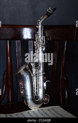 Un saxophone argenté sur une vieille chaise Banque D'Images
