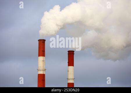 Fumeurs de pipes sur fond de ciel nuageux. Concept de centrale à vapeur, pollution de l'air, saison de chauffage ou cheminée d'usine Banque D'Images