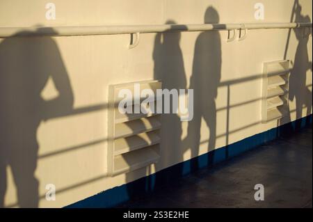 silhouettes de passagers penchés sur la main courante et grilles de ventilation sur le pont extérieur du ferry Banque D'Images