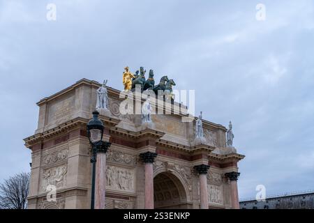 Magnifique arc historique se dresse haut sous un ciel nuageux dans un environnement urbain animé avec un chariot doré sur le dessus Banque D'Images