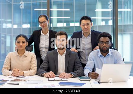 Portrait d'équipe d'affaires, groupe de gens d'affaires assis à une table de conférence et regardant la caméra, des gens sérieux et confiants divers. Banque D'Images
