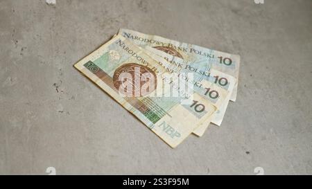 Billets de banque en zloty polonais placés sur une surface en béton illustrant le financement de devises en pologne avec des billets de dix zloty nets montrant un design détaillé contre th Banque D'Images