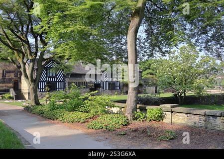 Shibden Hall à Halifax, un manoir anglais historique vu à travers les arbres, avec un jardin luxuriant au premier plan. Calderdale, West Yorkshire, Royaume-Uni Banque D'Images