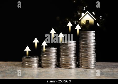 Marché immobilier. Pièces empilées, flèches, illustration de la maison et des signes de pourcentage sur fond noir. Hausse des taux d'intérêt Banque D'Images