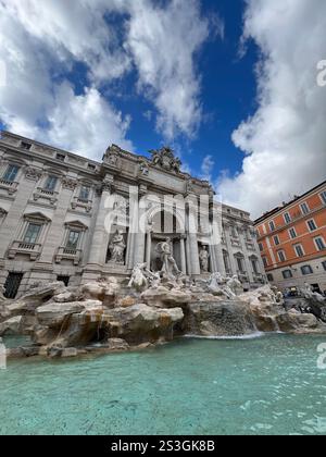 Photo grand angle de l'emblématique fontaine de Trevi à Rome lors d'une fête par temps nuageux. Une attraction touristique populaire présentant une architecture étonnante. Banque D'Images