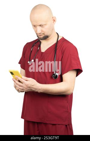 Un médecin chauve avec une barbe porte des gommages rouges et a un stéthoscope autour du cou. Banque D'Images