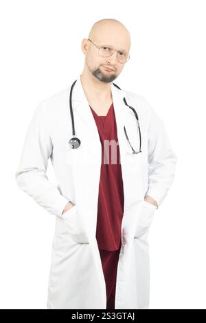 Un médecin chauve avec une barbe porte une blouse de laboratoire blanche sur des gommages rouges et a un stéthoscope autour de son cou. Banque D'Images