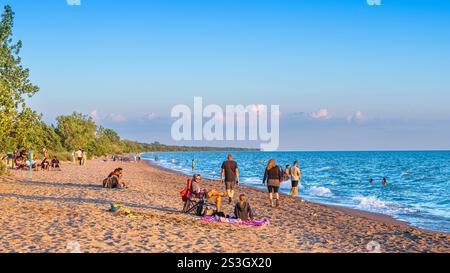 Les gens profitent d'un beau coucher de soleil sur la plage dans le parc national de la pointe Pelée un soir d'été. Banque D'Images