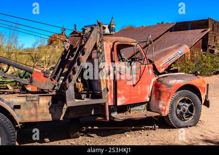 Un vieux camion rouge avec une extrémité avant cassée. Le camion est garé dans un terrain en terre battue Banque D'Images