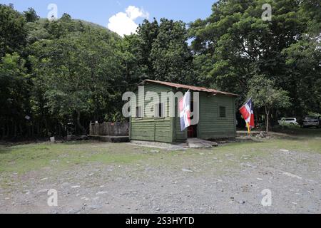 maison en bois vert d'un poste de garde dans la campagne, avec drapeau de la république dominicaine Banque D'Images