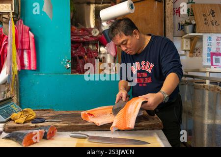 Taipei, Taiwan, 5 janvier 2025, homme coupant le saumon frais dans le marché de la rue Dongsanshui Banque D'Images