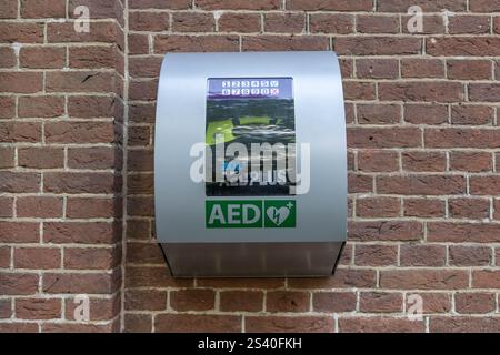 Geldrop, pays-Bas. 28 juin 2024. City AED monté sur un mur de briques de pierre. Un DAE, ou un défibrillateur externe automatisé, est utilisé pour aider les patients à Banque D'Images