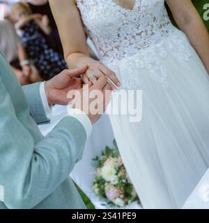 Le marié met la bague sur le doigt de la mariée. Photo de haute qualité Banque D'Images