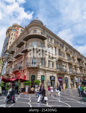 Bakou, Azerbaïdjan - 5 mai 2024 : les visiteurs se promènent le long de la rue Nizami, admirant l'architecture des bâtiments historiques. Les cafés et les boutiques invitent les clients à explorer l'atmosphère animée et la culture locale Banque D'Images