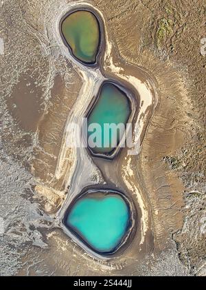 Vue aérienne de trois piscines glaciaires turquoises vibrantes, entourées de textures terreuses accidentées, mettant en valeur le contraste naturel époustouflant de l'Islande Banque D'Images