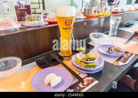 Erdinger weissbier bière de blé blanc et plats sur un tapis roulant, Fuji Sushi Bar Trier, Rhénanie-Palatinat, Allemagne Banque D'Images