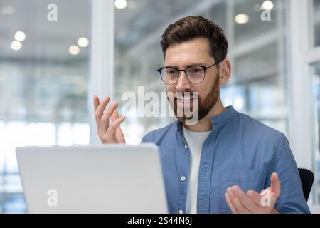 Appel vidéo, homme à l'intérieur du bureau en gros plan parler avec des collègues et des partenaires, employé utilisant un ordinateur portable pour la visioconférence en ligne et la réunion d'affaires en ligne. Banque D'Images