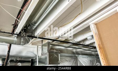 Conduits et plomberie exposés dans le sous-sol de construction neuve Banque D'Images