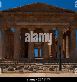 Fronton triangulaire simple et colonnes rainurées, s'élevant au-dessus d'une base de pierre, du temple dorique de Concordia dans la vallée des temples (la Valle dei Templi) à Agrigente, Sicile, Italie, site de la cité grecque antique d'Akragas. Banque D'Images