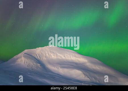 Incroyable exposition d'Aurora Borealis aka Northern Lights dans l'Arctique Tromso, Norvège. Merveilleux spectacle de lumière dans les montagnes enneigées. Banque D'Images
