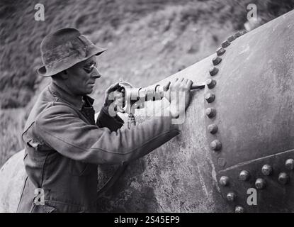 Construction de conduites rendant étanches les joints des conduites au moyen d'une machine à calfeutrer pneumatique. (24 août 1923) par Leslie Adkin Banque D'Images
