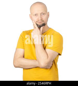 Un homme chauve avec une barbe courte portant un t-shirt jaune pose sur un fond blanc Uni. Banque D'Images