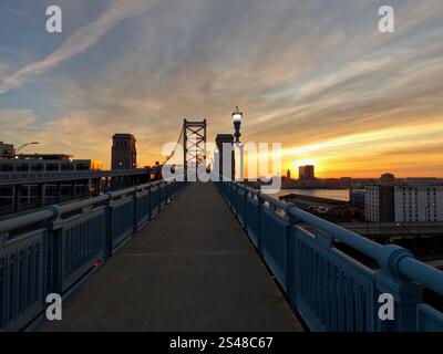 Le soleil se lève sur le pont Benjamin Franklin sur le Delaware River entre Camden et Philadelphie. Banque D'Images