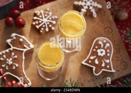 Deux verres d'Eiecognac sur une table en bois avec des biscuits de Noël en pain d'épices décorés, vue de dessus Banque D'Images
