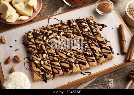 Barres de snack maison à base de poudre de protéines de lactosérum, flocons d'avoine, sirop d'érable, cannelle et beurre de noix enrobés de chocolat Banque D'Images