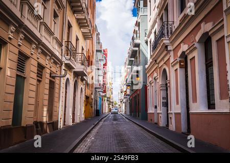 San Juan, Porto Rico - 25 février 2018 : une voiture prend appui sur l'étroite calle colorée pavée Calle Tetuan dans le vieux San Juan. Banque D'Images