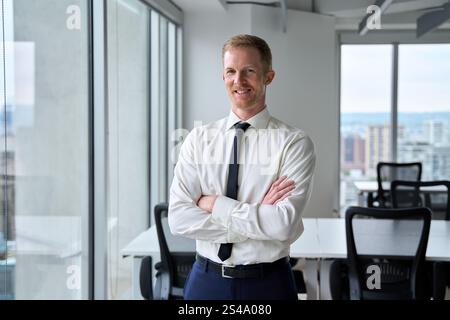 Souriant jeune homme d'affaires confiant regardant la caméra dans le bureau, portrait. Banque D'Images