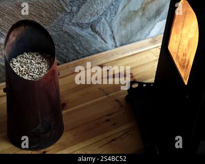 Les granulés de bois dans la trémie à granulés sont à côté du poêle à cheminée moderne Banque D'Images