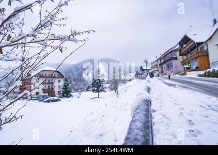 Scène de rue enneigée dans un village avec vue sur les collines environnantes en hiver, Enzkloesterle, district de Calw, Forêt Noire, Allemagne, Europe Banque D'Images