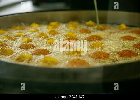Préparation et friture de boules de falafel au marché turc de Kreuzberg, Berlin. Banque D'Images