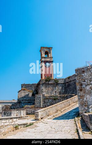 L'emblématique tour de l'horloge de la vieille forteresse de Corfou, en Grèce, debout fièrement contre un ciel bleu clair Banque D'Images