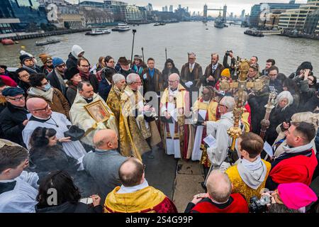 Londres, Royaume-Uni. 12 janvier 2025. La bénédiction de la Tamise a lieu dans le centre de London Bridge par le Père Philip Warner, cardinal recteur de St Magnus et le très révérend Dr Mark Oakley, doyen de Southwark. Le court service voit le rassemblement du clergé et des congrégations de la cathédrale de Southwark et de Saint Magnus le Martyr - églises assis de chaque côté de la rive de la rivière. Des prières sont offertes aux usagers du pont et de la rivière - y compris la RNLI et la police fluviale - ainsi qu'à ceux qui sont morts dans la Tamise. Une croix en bois est jetée dans les eaux. Crédit : Guy Bell/Alamy Live Banque D'Images