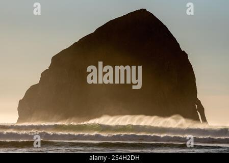 Waves et Haystack Rock au large de Pacific City, Oregon. Banque D'Images