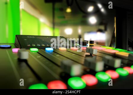 Produisez un studio vidéo de film avec des caméras, une console de mixage, des projecteurs et un fond d'écran vert rond pour la technologie de chrominance et la post-production. Banque D'Images