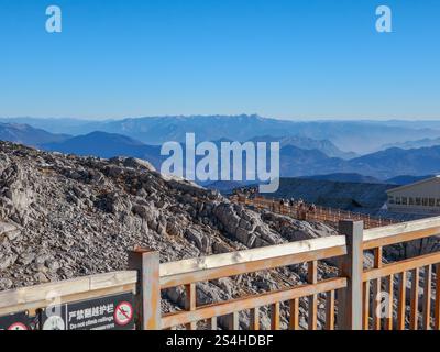 Touristes marchant sur Trestle Wooden Bridge route visitant et appréciant le sommet de la montagne enneigée du Dragon de Jade, la célèbre destination touristique à Lijiang, Banque D'Images