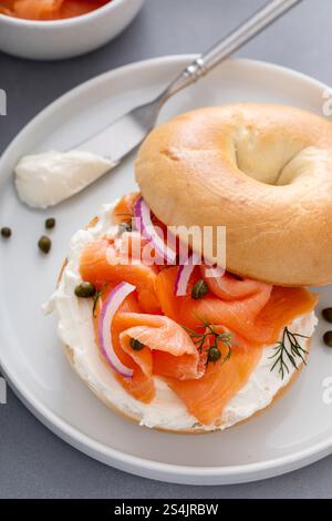 Bagel au saumon fumé plaqué avec fromage à la crème sur une table de cuisine moderne Banque D'Images