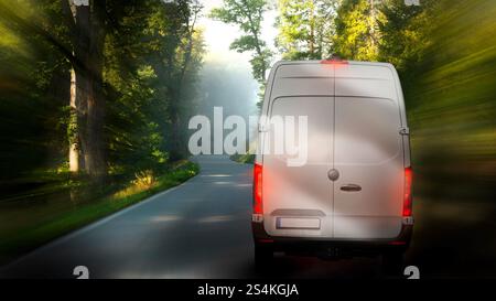 Le service de colis conduit rapidement des colis express le long de la route de campagne dans la forêt des montagnes. Livraison et logistique 24 heures. Banque D'Images