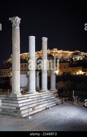 Colonnes corinthiennes des ruines de la bibliothèque d'Hadrien sur la place Monastiraki en face de l'Acropole à Athènes la nuit Banque D'Images