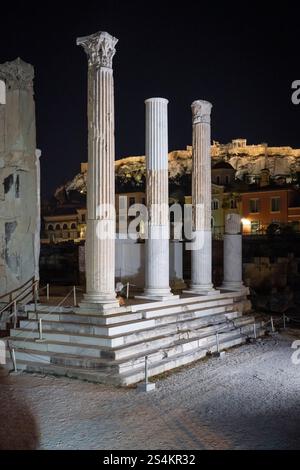 Colonnes corinthiennes des ruines de la bibliothèque d'Hadrien sur la place Monastiraki en face de l'Acropole à Athènes la nuit Banque D'Images