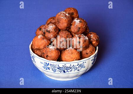 Bol avec oliebollen sur une nappe bleue Banque D'Images