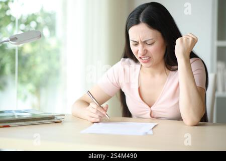 Femme asiatique en colère lisant le contrat avant de le signer à la maison Banque D'Images